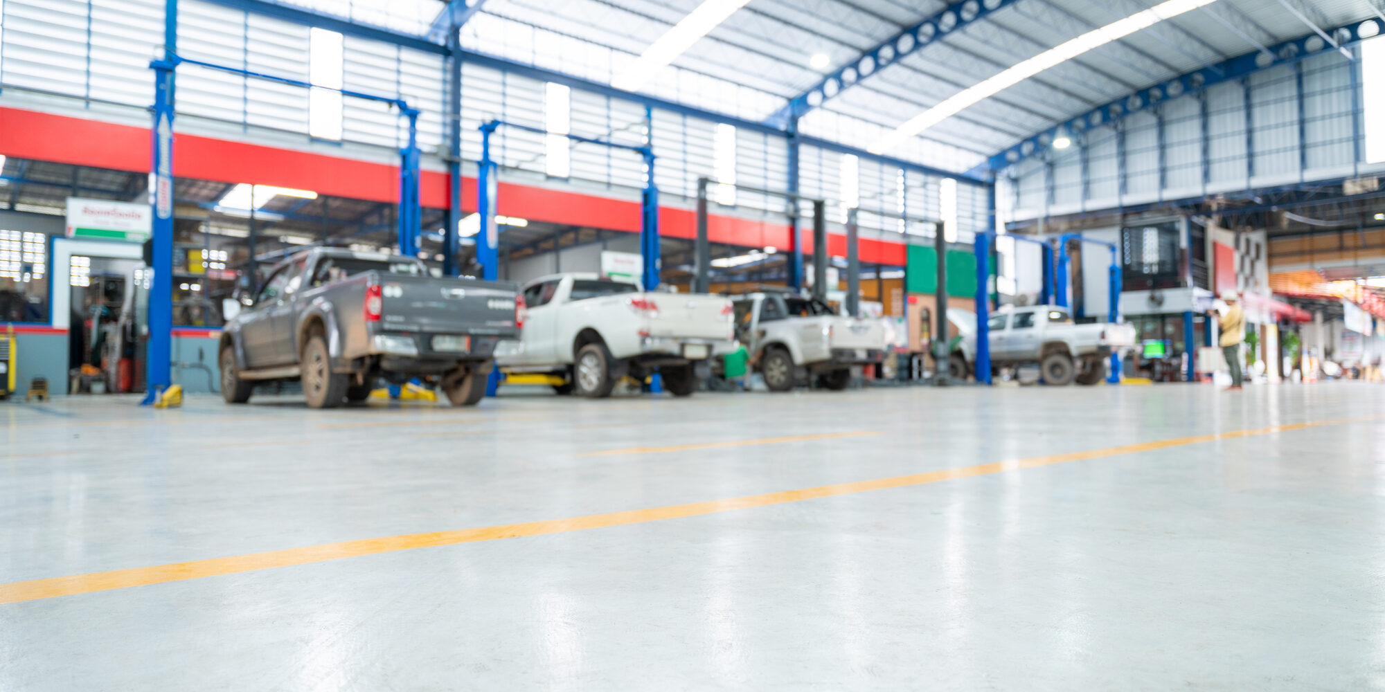 Blurred background of Car repair station paved with epoxy floor and electric lift for a car that comes to change the engine oil in the background of Car repair center with epoxy floors.